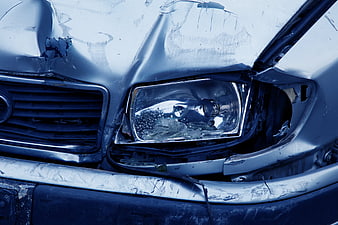 Close-up of damaged car headlight and bumper after accident