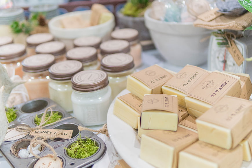 Handmade artisan soap bars and candles on display table