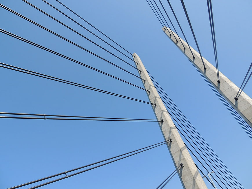 Low Angle View of Cable-Stayed Bridge Towers Against Blue Sky