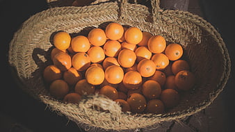 Top View of Fresh Oranges in Woven Straw Basket