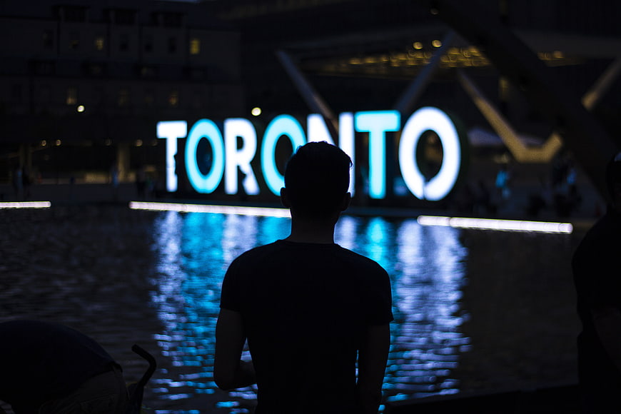 Silhouette of Man Viewing Toronto Sign at Night