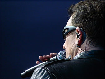 Close-up of male singer performing with microphone and sunglasses