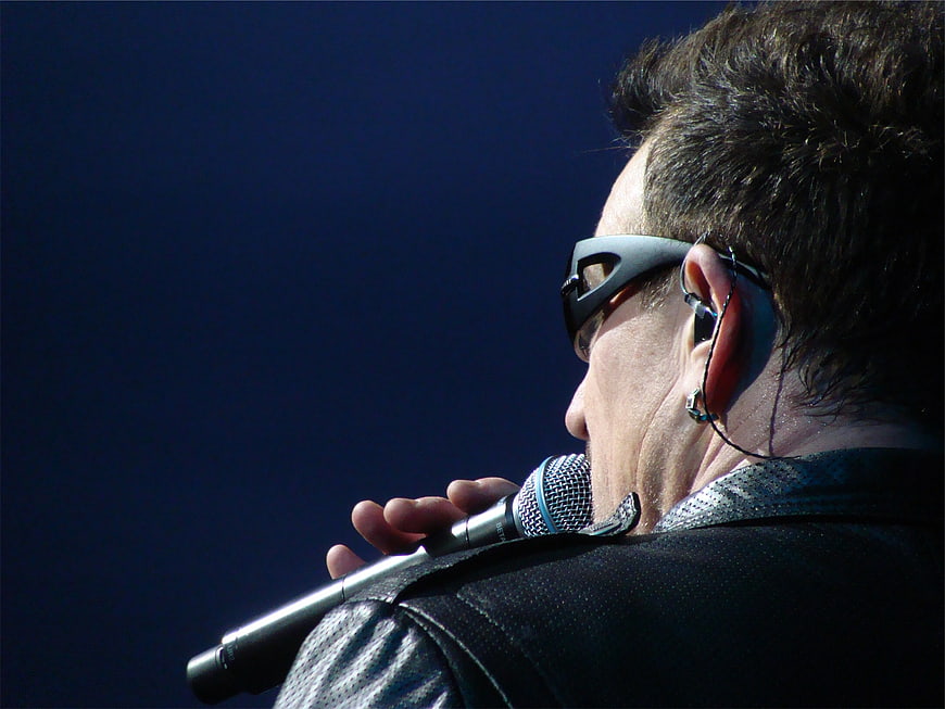 Close-up of male singer performing with microphone and sunglasses
