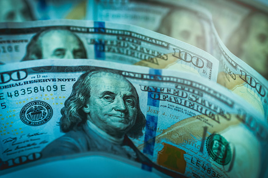 Close-up of US one hundred dollar bills with blue tint