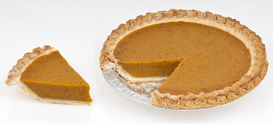 Whole Pumpkin Pie With Slice On White Background