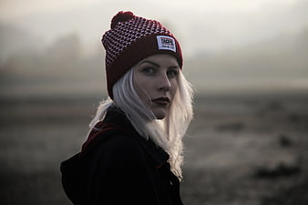 Woman in Red Beanie Looking Back in Foggy Landscape