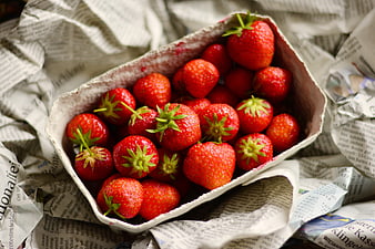 Fresh Red Strawberries in a Cardboard Box on Newspaper