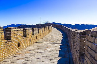 Great Wall of China stone pathway and crenellations under blue sky
