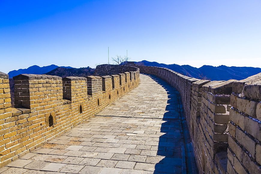 Great Wall of China stone pathway and crenellations under blue sky