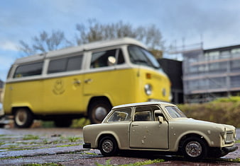 Vintage Trabant toy car with yellow VW bus background