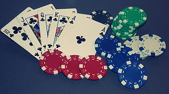Royal Flush in Clubs with Poker Chips on Blue Felt