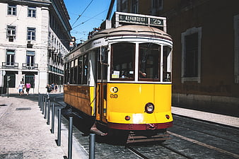 Vintage Yellow Tram on Cobblestone Street in Lisbon