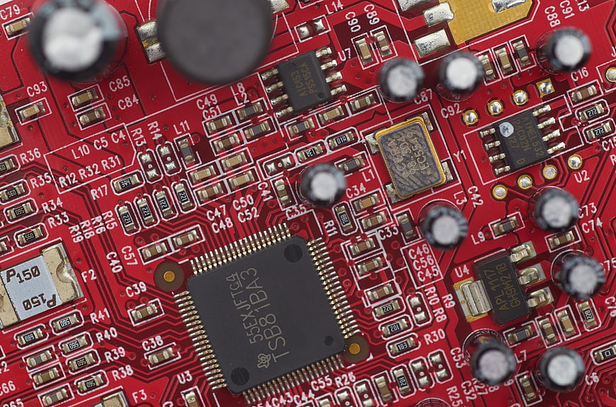 Close-up of red electronic circuit board with microchip