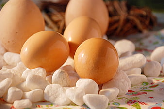 Brown eggs on white stones with Easter tablecloth