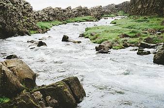 Flowing River Through Rocky Canyon with Green Banks