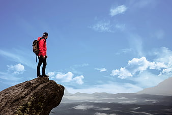 Hiker in Red Jacket Standing on Mountain Cliff Edge