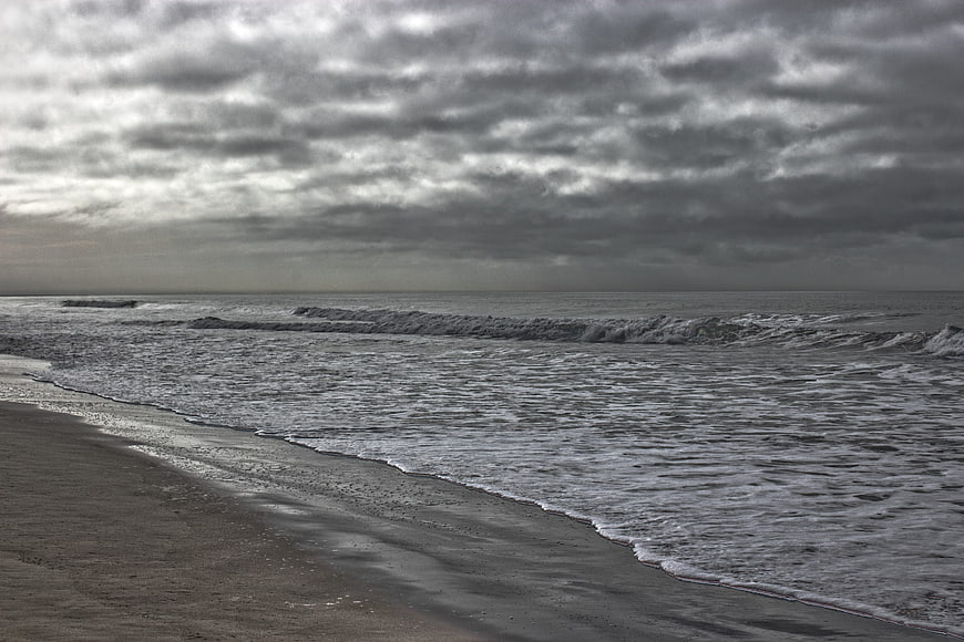 Moody Overcast Beach Scene with Rolling Waves and Gray Sky