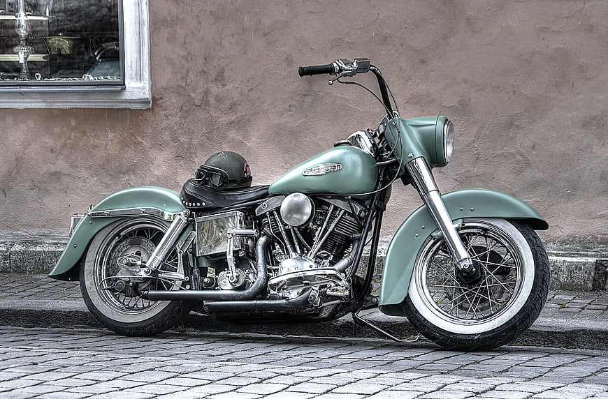 Vintage Green Motorcycle Parked on Cobblestone Street