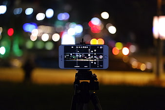 Smartphone on Tripod Capturing City Bokeh at Night
