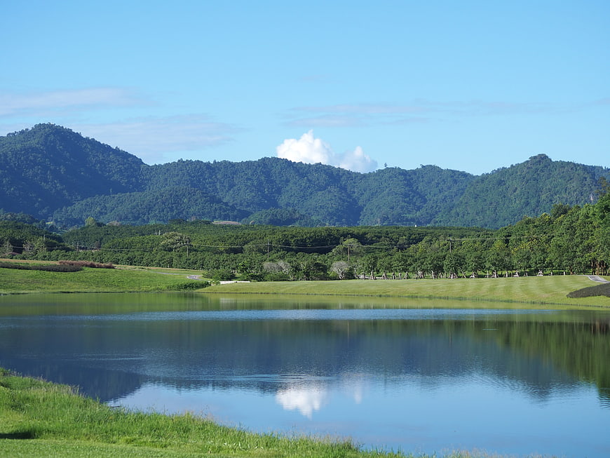 Serene lake reflecting mountains and blue sky in lush landscape