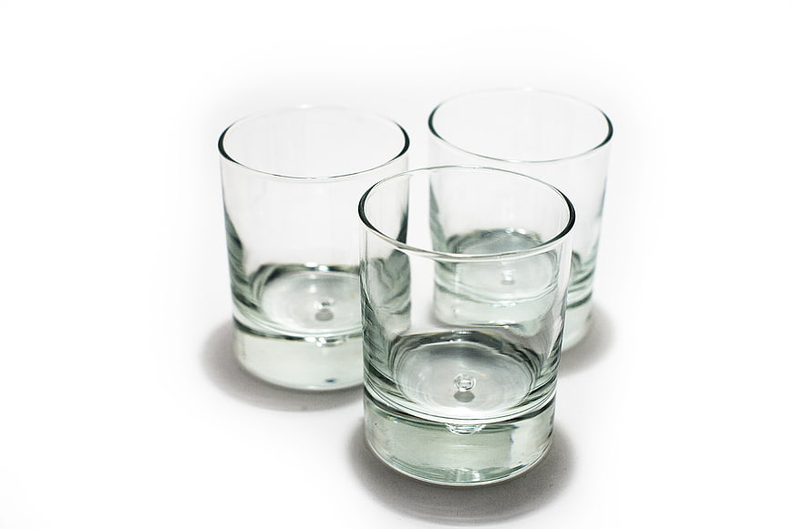 Three Empty Clear Glass Tumblers on White Background