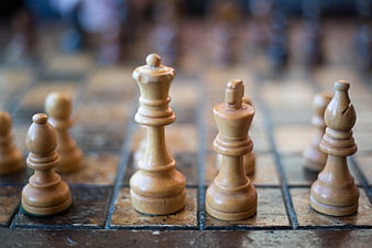 Close-up of wooden chess pieces on a vintage board
