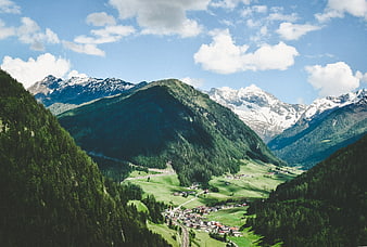 Scenic Alpine Valley with Snow-Capped Peaks and Village
