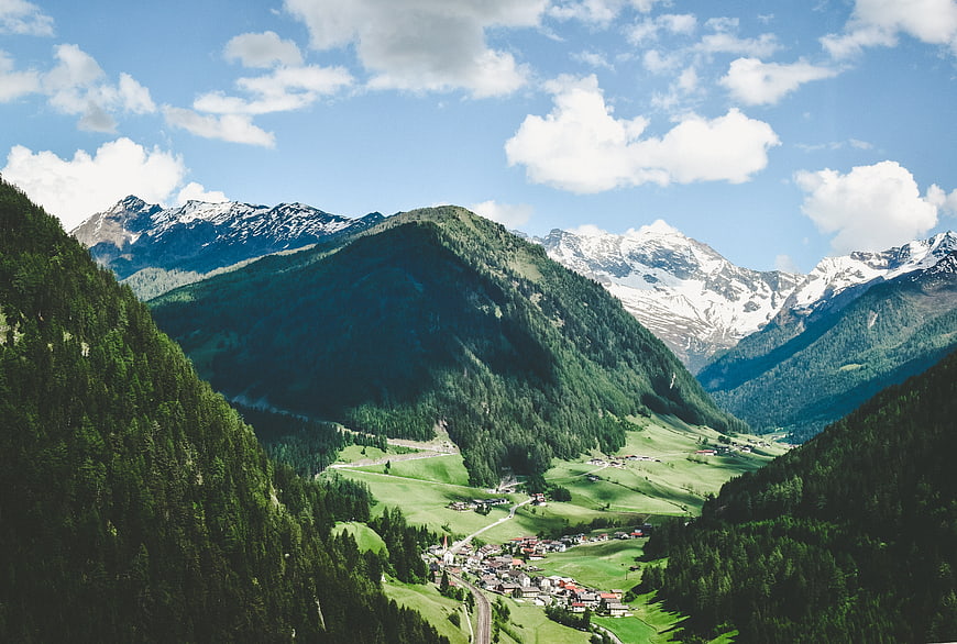 Scenic Alpine Valley with Snow-Capped Peaks and Village
