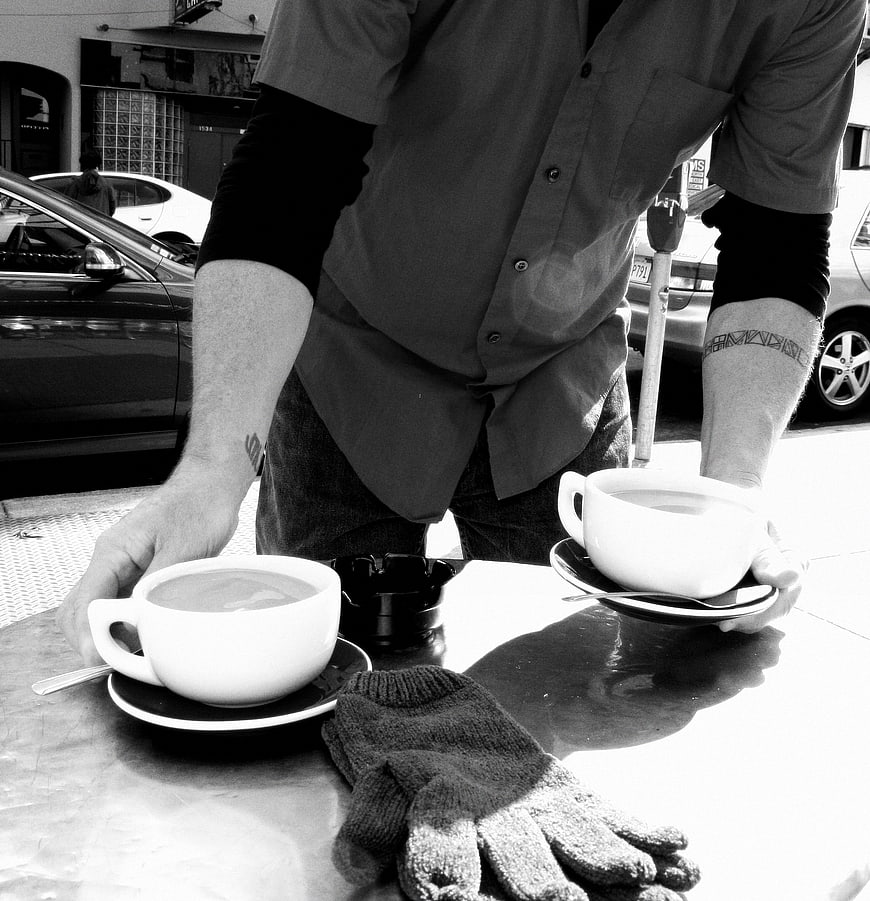 Barista serving coffee outdoors in black and white