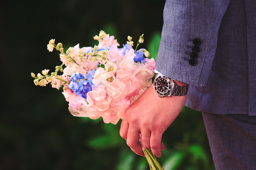 Man in Suit Holding Pink and Blue Flower Bouquet