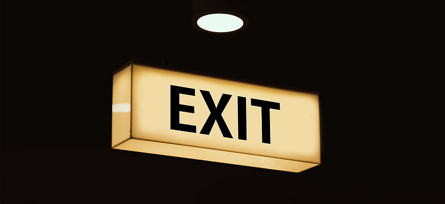 Illuminated Exit Sign in Dark Room
