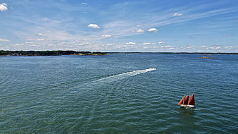 Aerial View of Red Sailboat and Motorboat on Blue Sea