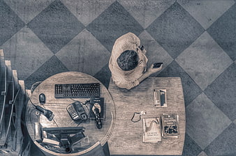 Top-down view of man working at wooden desk with books