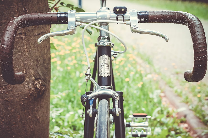 Close-up of Vintage Bicycle Handlebars Leaning Against Tree