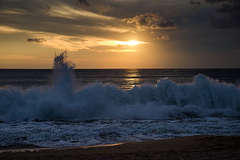 Dramatic Ocean Waves Crashing at Sunset on Sandy Beach