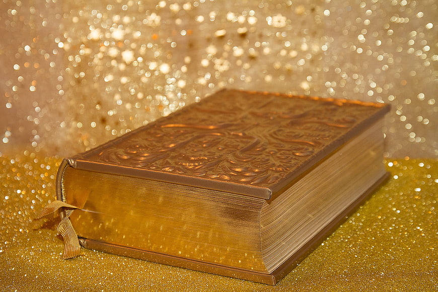 Golden Holy Bible on Glittering Background