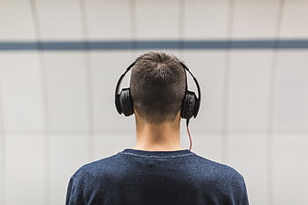 Back view of man wearing headphones listening to music