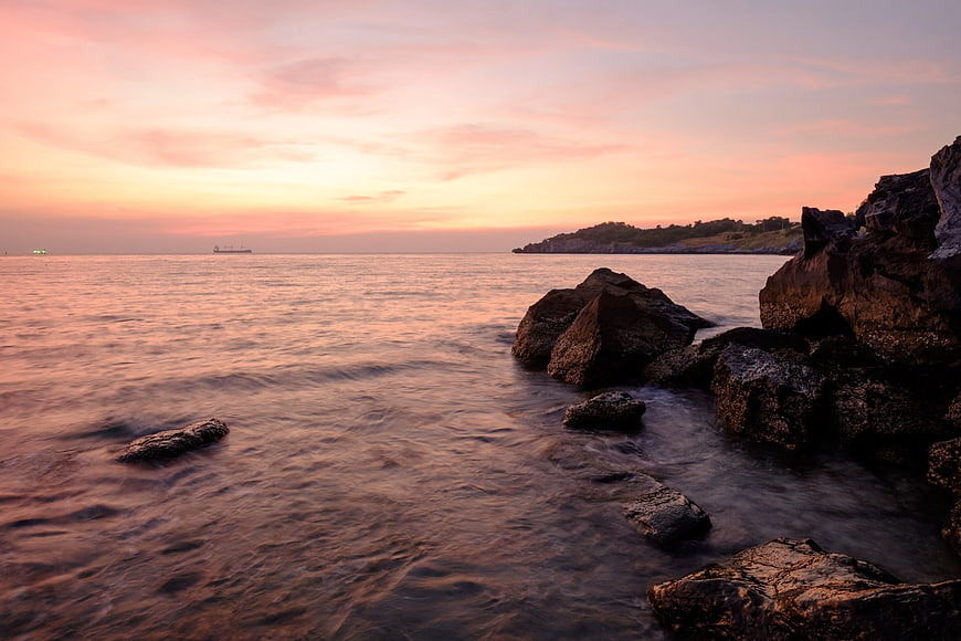 Serene Sunset Seascape with Rocky Shoreline and Silky Water