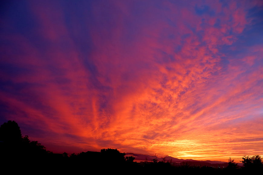 Vibrant Red and Purple Sunset Sky with Silhouette