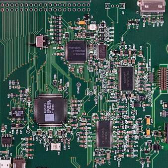 Close-up of green circuit board with microchips and electronic components
