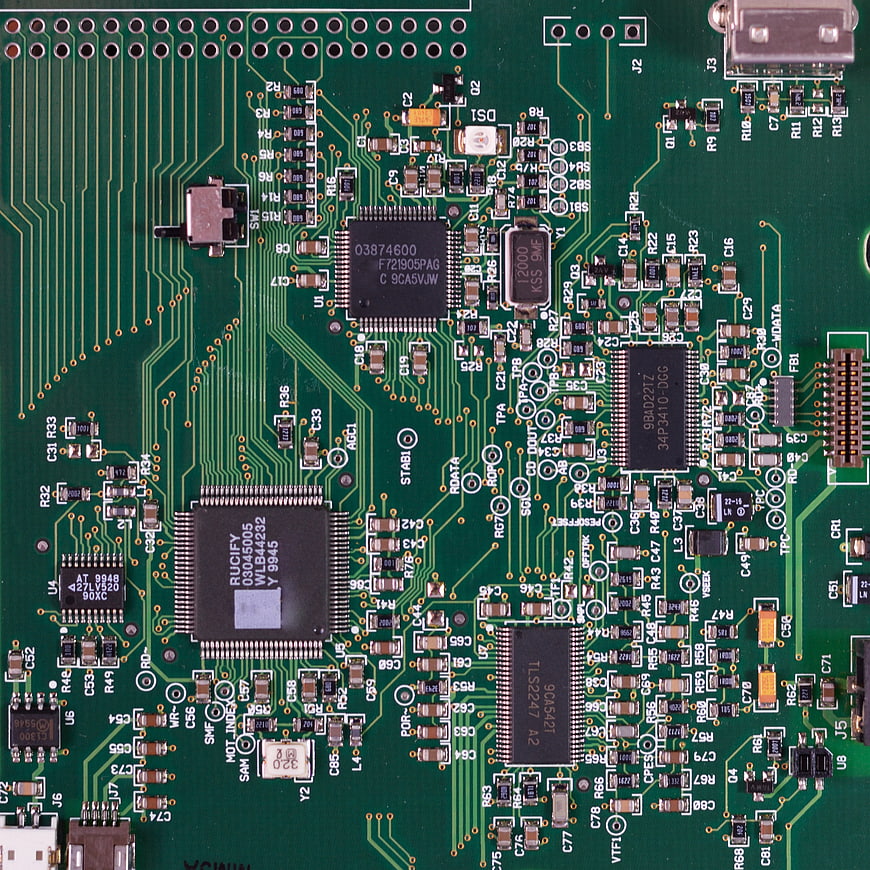 Close-up of green circuit board with microchips and electronic components