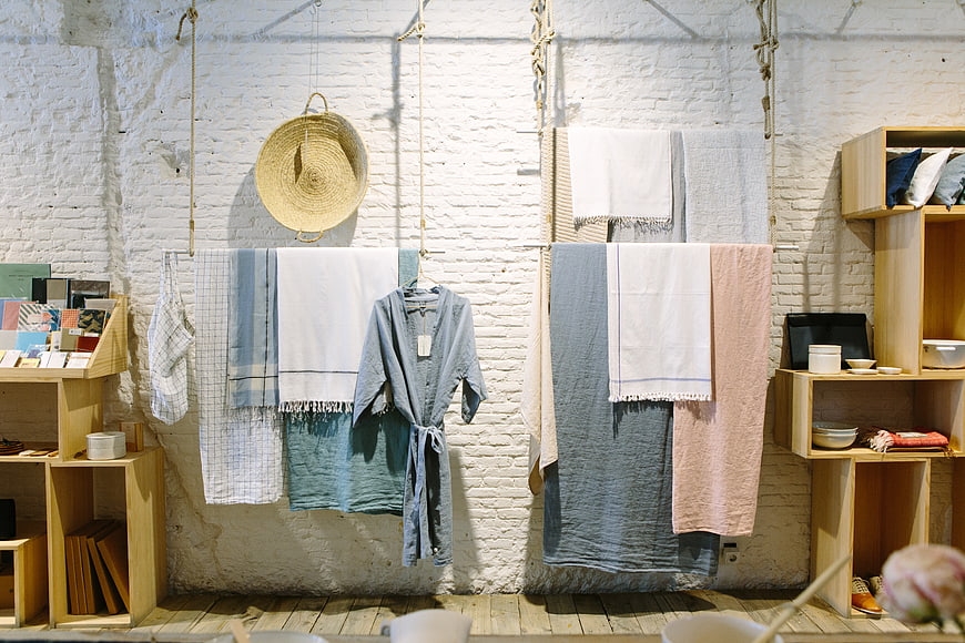 Boho home decor shop interior with linens and wooden shelves