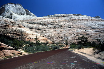 Paved road winding through desert landscape with white rock formations