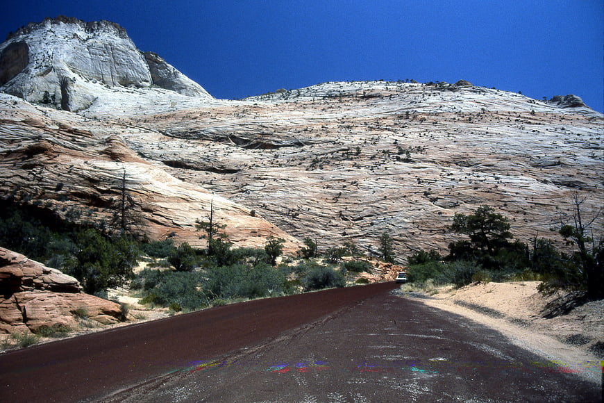 Paved road winding through desert landscape with white rock formations