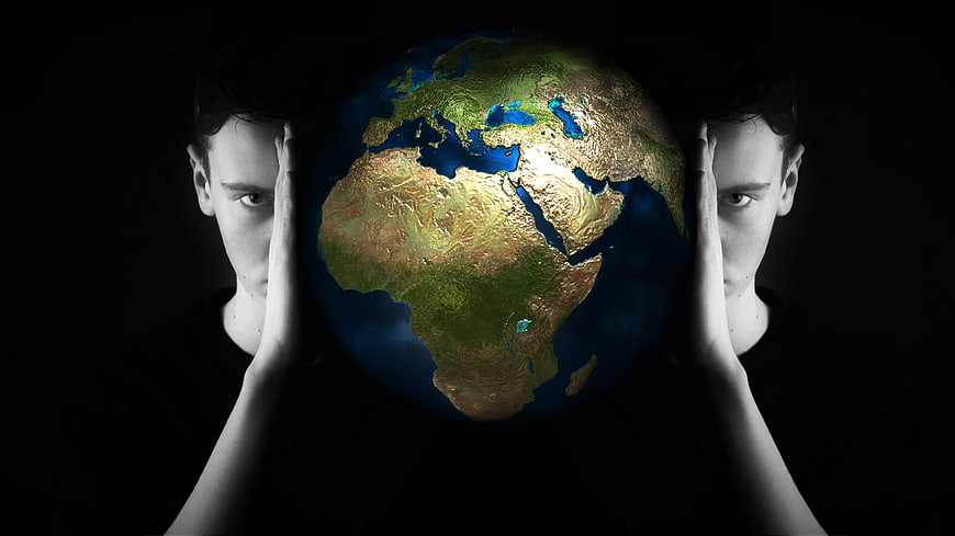 Conceptual man holding 3D globe of Africa and Europe in dark space