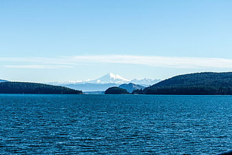 Serene Blue Ocean View with Distant Snow-Capped Mountain