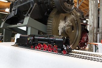 Detailed black steam locomotive model train with red wheels
