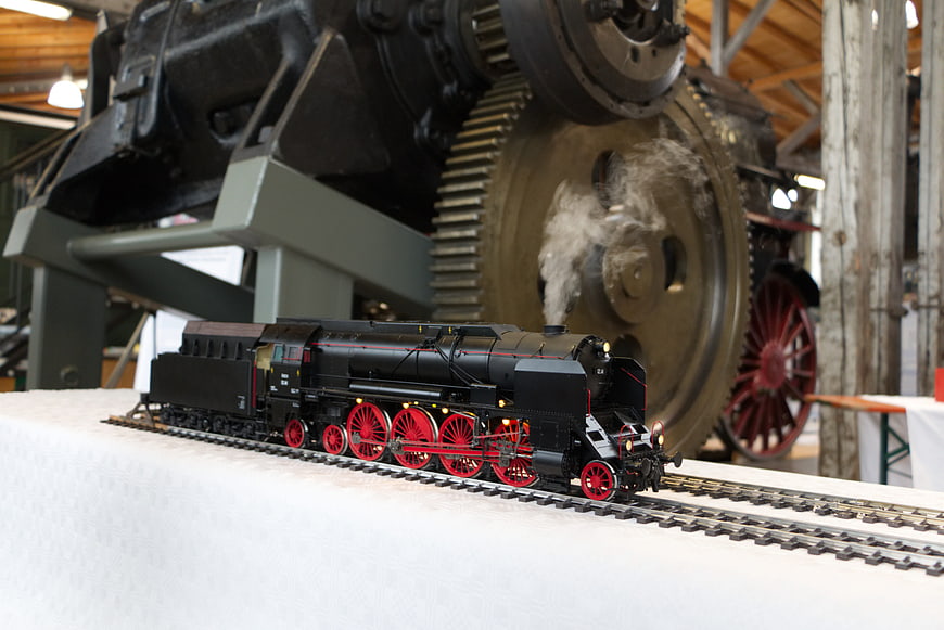 Detailed black steam locomotive model train with red wheels