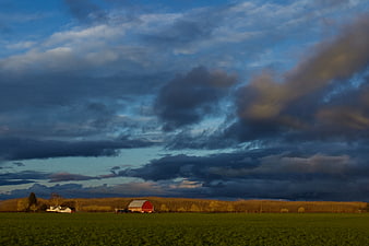 Red Barn Farm Landscape Under Dramatic Cloudy Sky