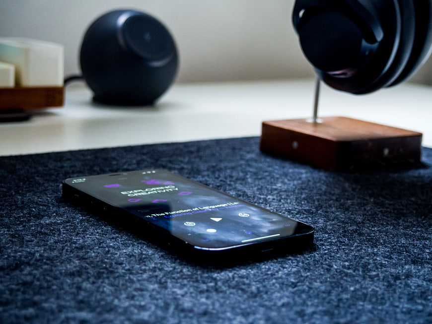 Smartphone Playing Podcast on Desk with Headphones
